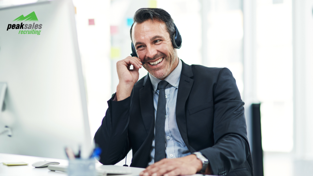 Smiling businessman with headphones using a computer in an office